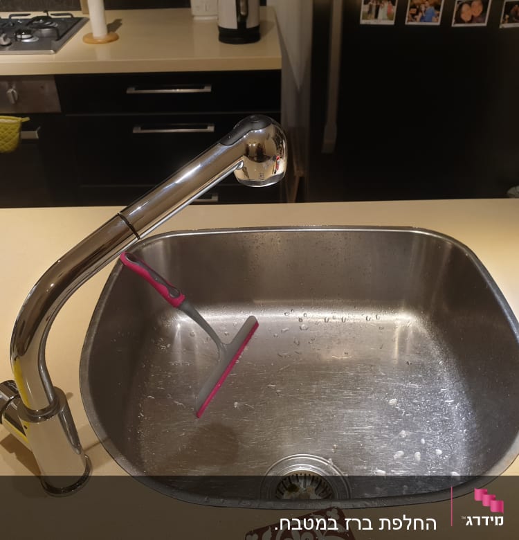 ברז נירוסטה מעל כיור מטבח עם מגב קטן